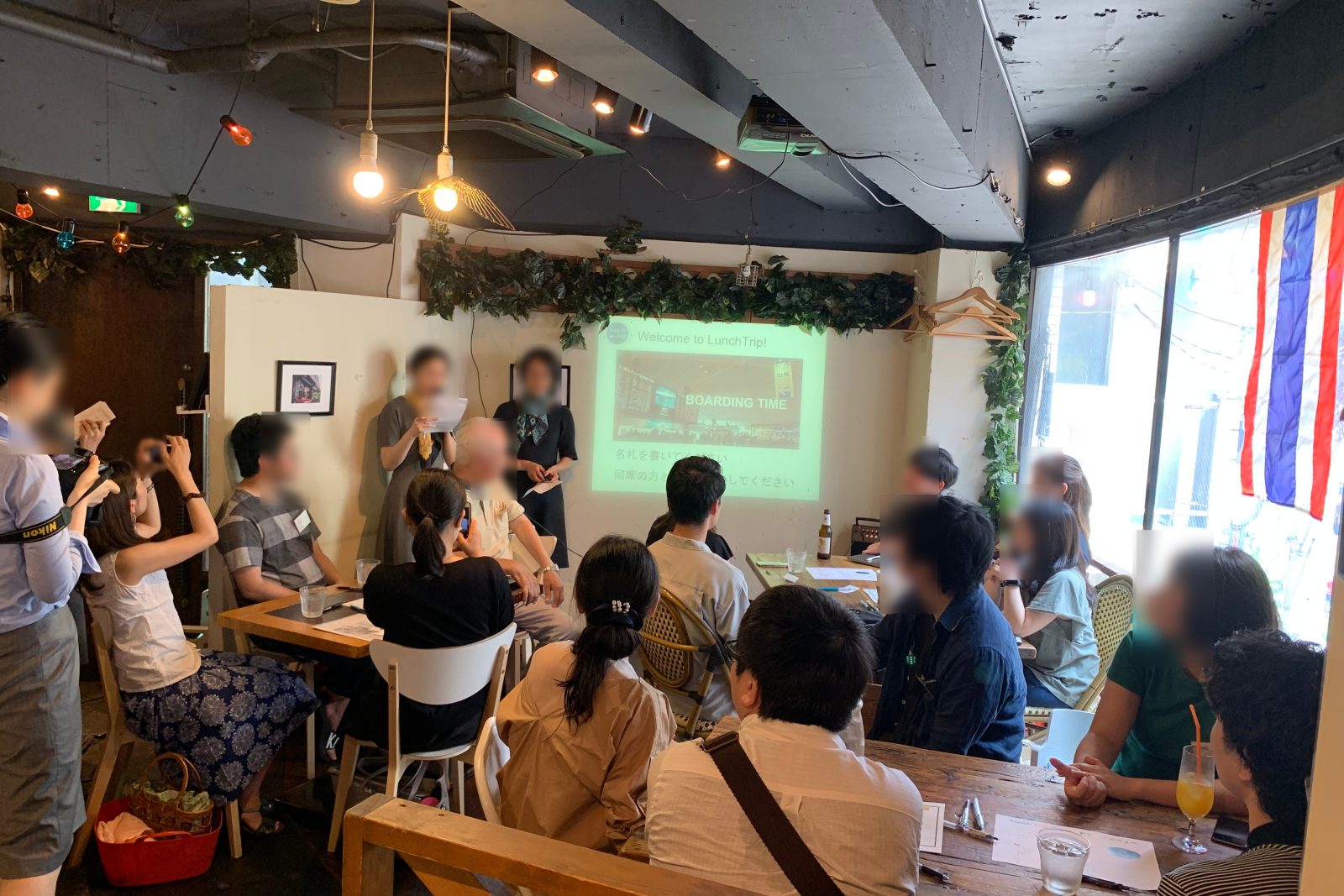 A full room listening to a guide, with the Thai flag in the window, Ebisu 2019